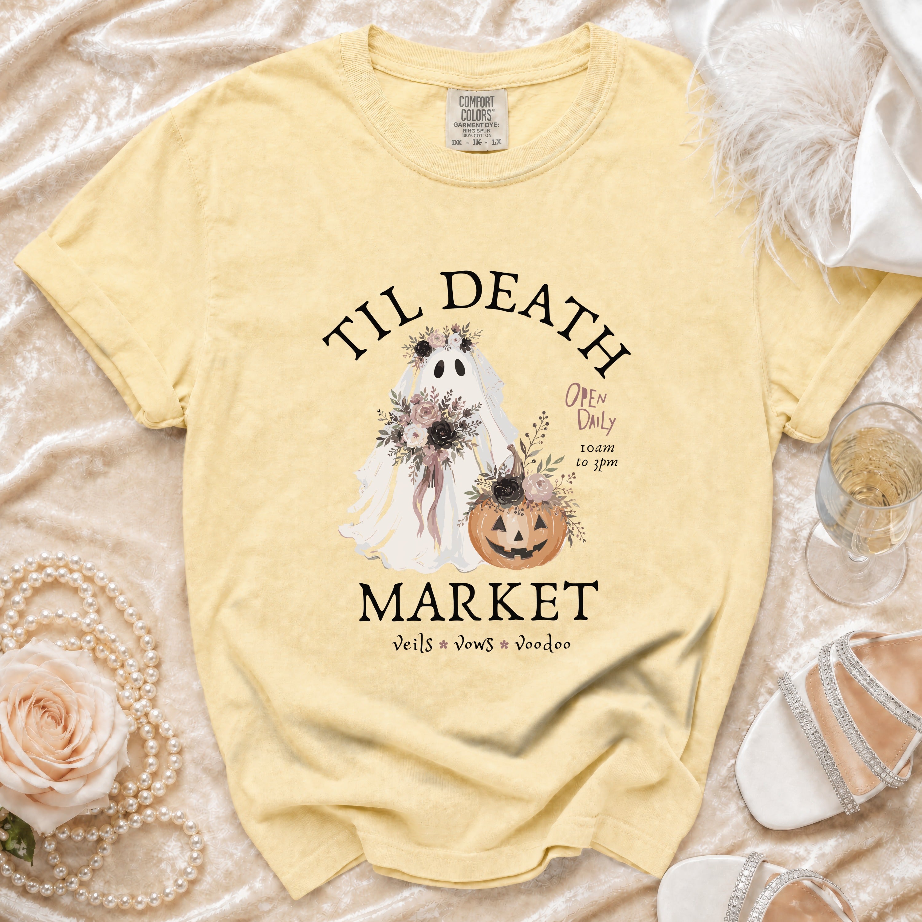 Yellow t-shirt with ghost, pumpkin, and text: "Til Death Market Veils Vows Voodoo".