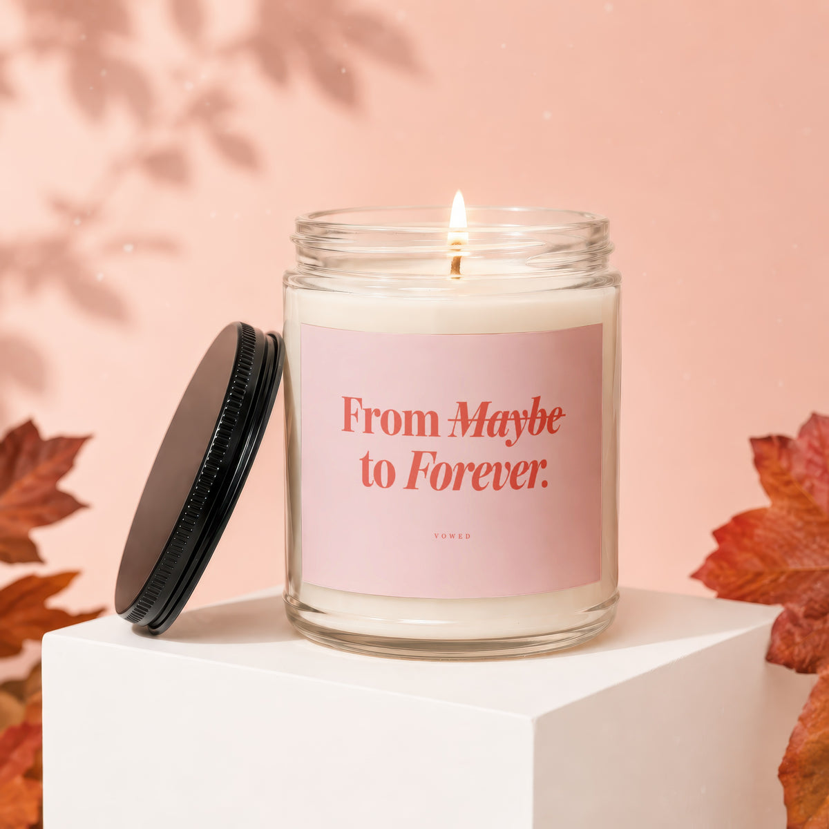 Glass candle with pink label reading "From Maybe to Forever. VOWED."