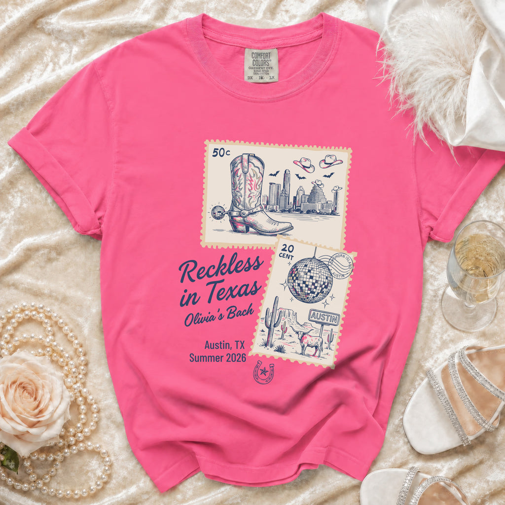 Pink t-shirt with "Reckless in Texas Olivia's Bach" text and stamp graphics.