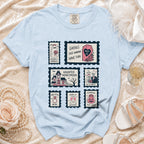 Light blue t-shirt with ghost, coffin, haunted house, and skeleton wedding-themed stamps.