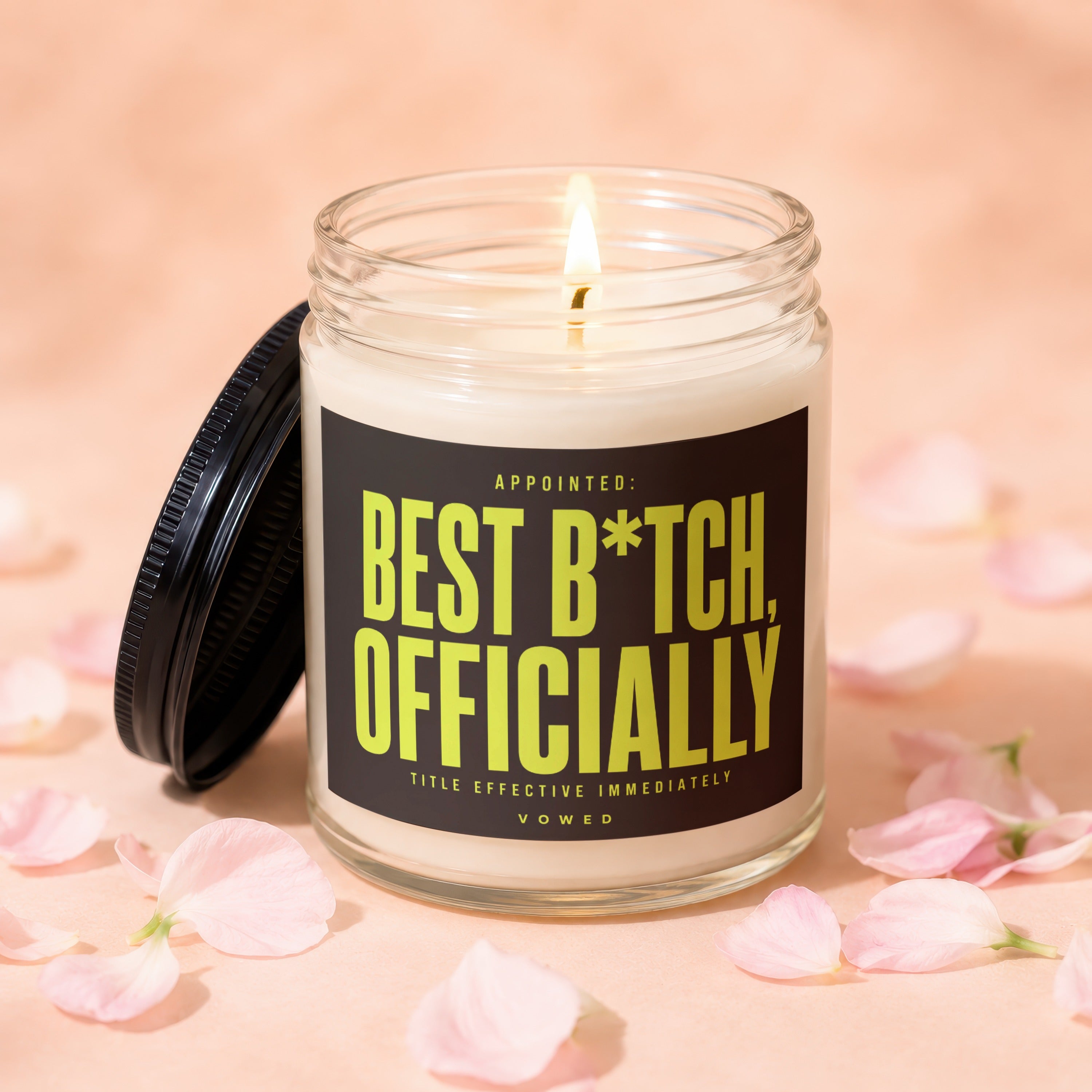 Glass candle with lit wick and label "Appointed: Best B*tch, Officially".