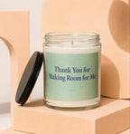 Glass candle with green label that reads "Thank You for Making Room for Me."