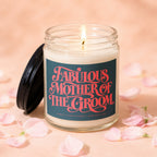Candle labeled "Fabulous Mother of the Groom" with lit wick, surrounded by petals.