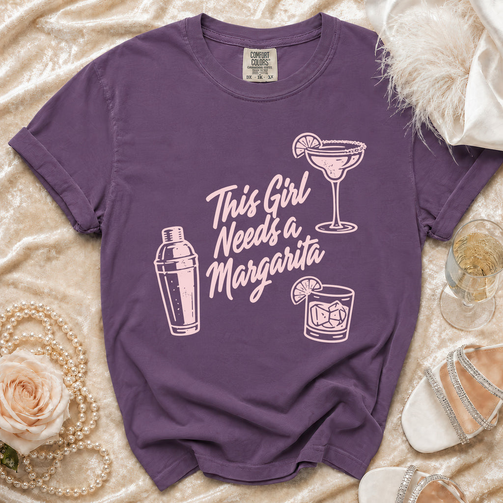 Purple t-shirt with "This Girl Needs a Margarita" text and drink illustrations.