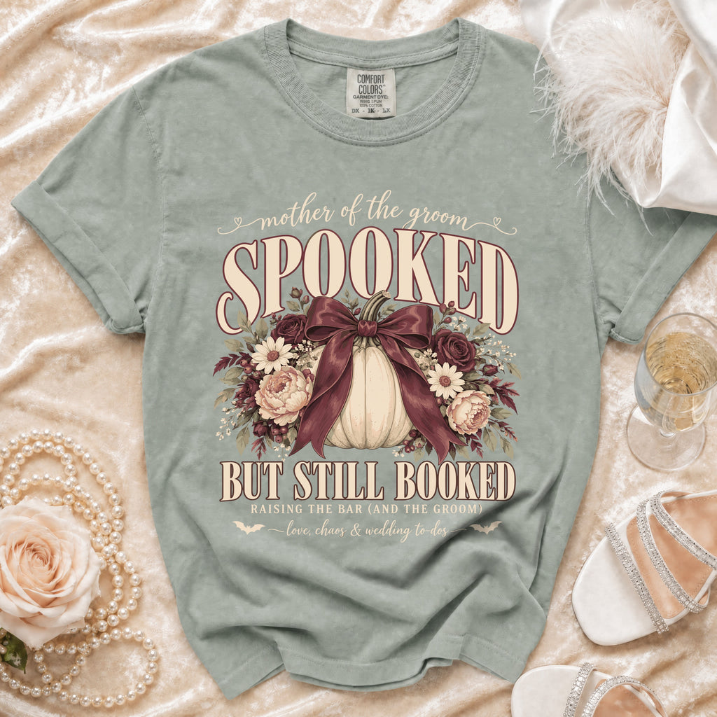 Green t-shirt with "Mother of the Groom Spooked But Still Booked" text and pumpkin graphic.