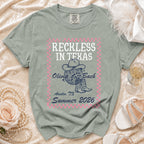 "Reckless in Texas" t-shirt with cowgirl hat, boots, and text.