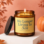 Amber jar candle with lit flame, yellow label reads "No Longer Living In Sin".