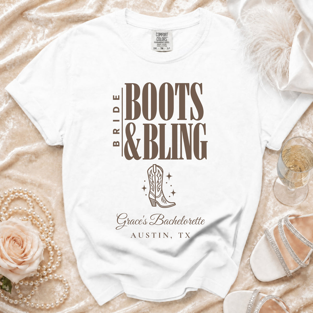 A white t-shirt with brown text reading Bride Boots & Bling, a cowboy boot graphic, and Grace's Bachelorette Austin, TX.