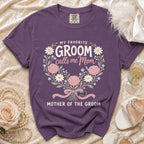 Purple t-shirt with "My Favorite Groom calls me Mom, Mother of the Groom" text and floral design.