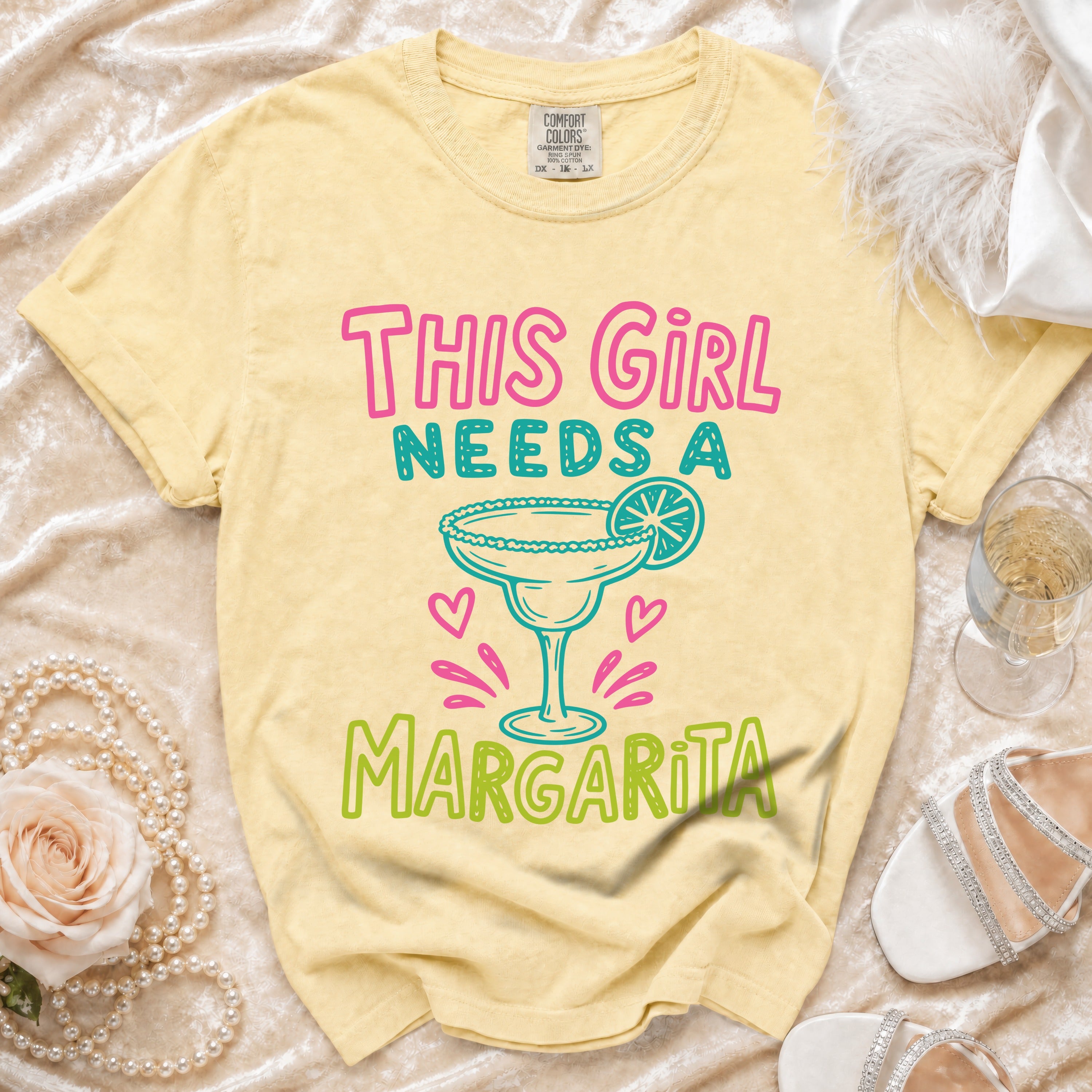 Yellow t-shirt with "This Girl Needs A Margarita" graphic and margarita glass.