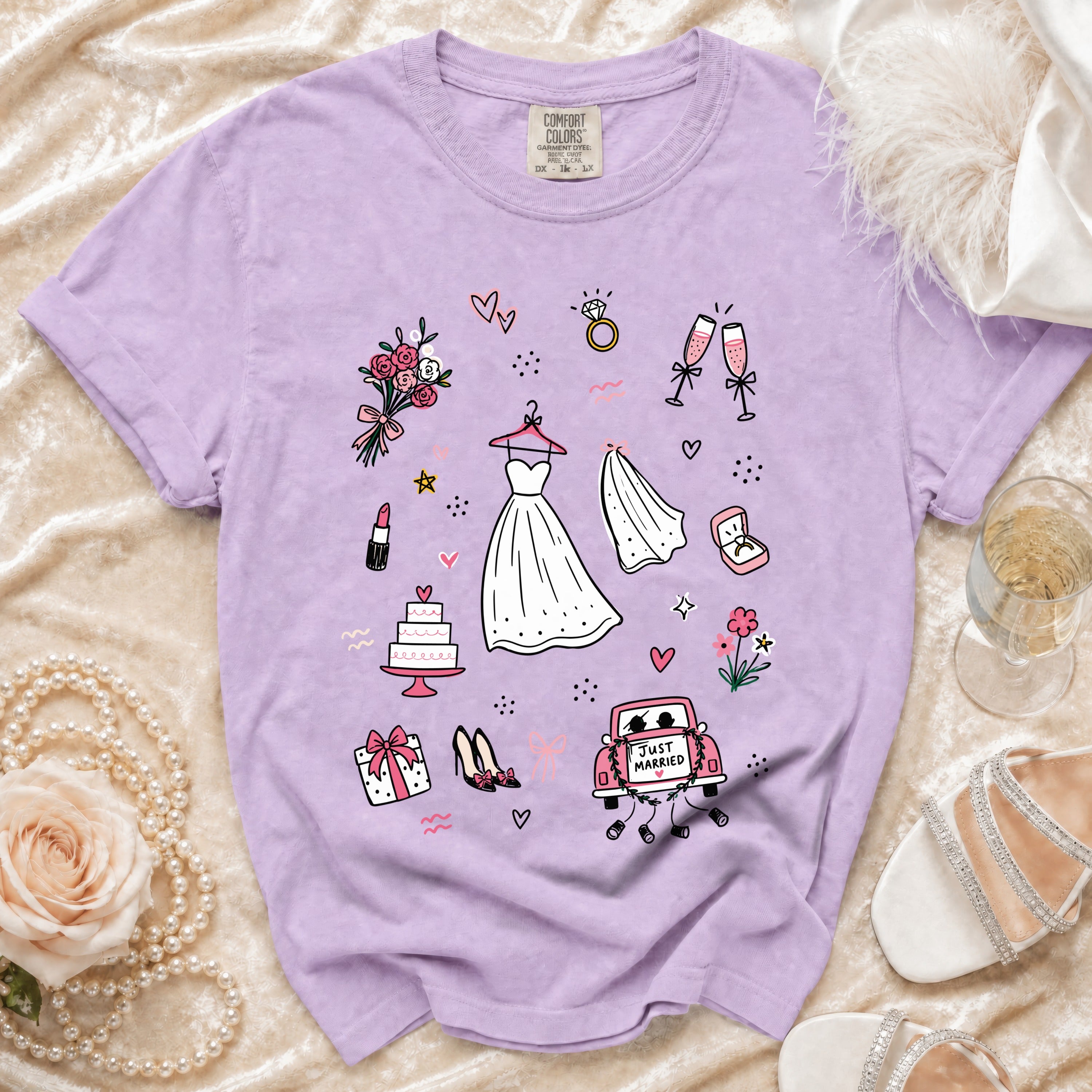 Lavender t-shirt with wedding icons: dress, veil, cake, car, and "JUST MARRIED" text.