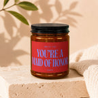 Amber candle in jar with red label reading "Smells Like You're A Maid of Honor"