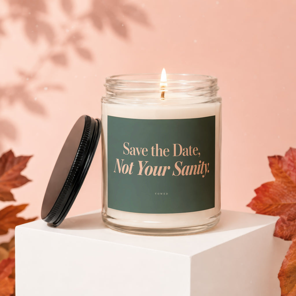 Glass candle with lit wick, black lid, and text "Save the Date, Not Your Sanity."