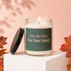 Glass candle with lit wick, black lid, and text "Save the Date, Not Your Sanity."