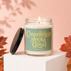 Candle with lit wick, "Commitment Looks Good" text, and fallen leaves decoration.
