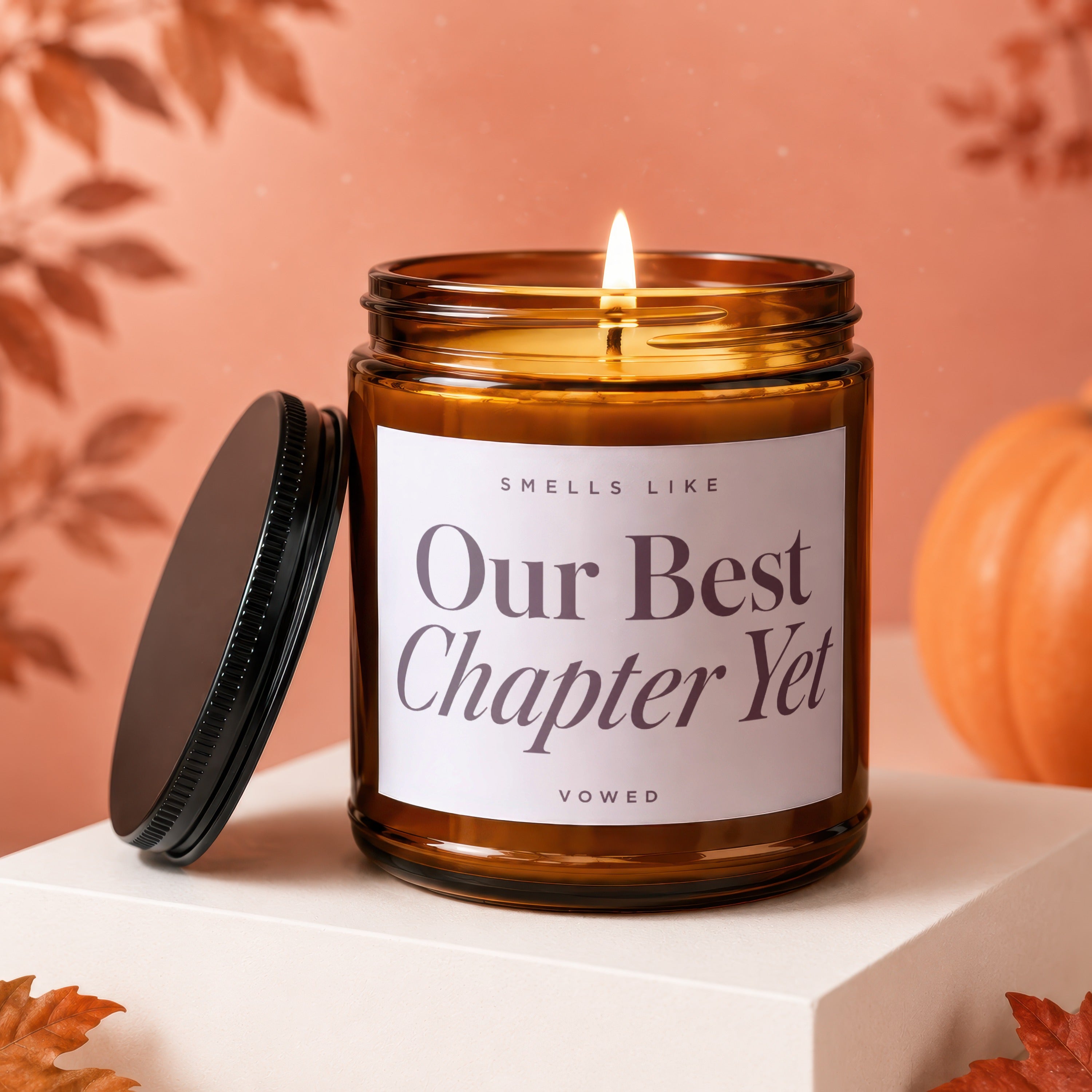 Amber jar candle with lit flame reads "Our Best Chapter Yet Vowed".