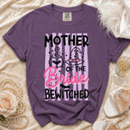 Purple t-shirt with "Mother of the Bride Bewitched" text and Halloween graphics.