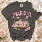 T-shirt with "MARRIED" and bride and groom in pink convertible.