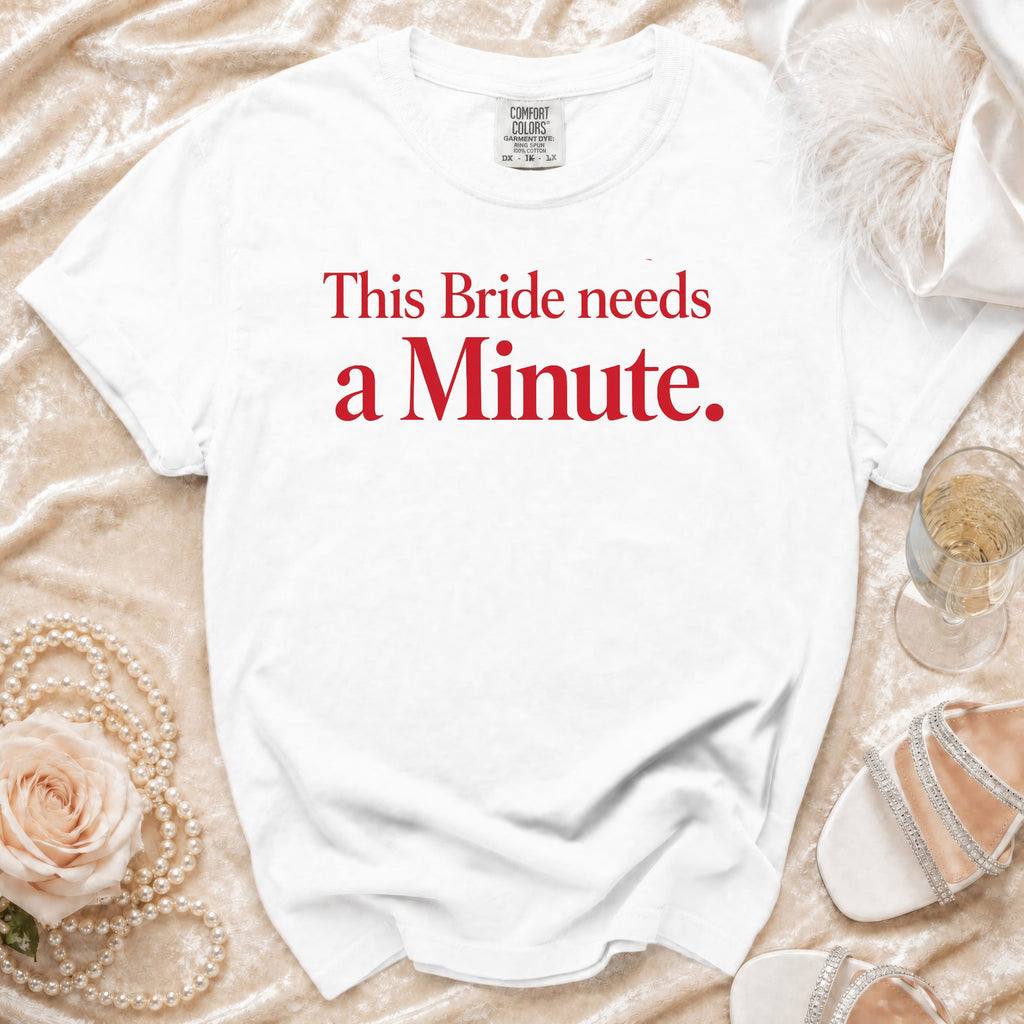 White t-shirt with red text "This Bride needs a Minute."