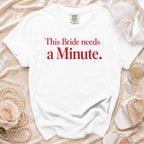 White t-shirt with red text "This Bride needs a Minute."