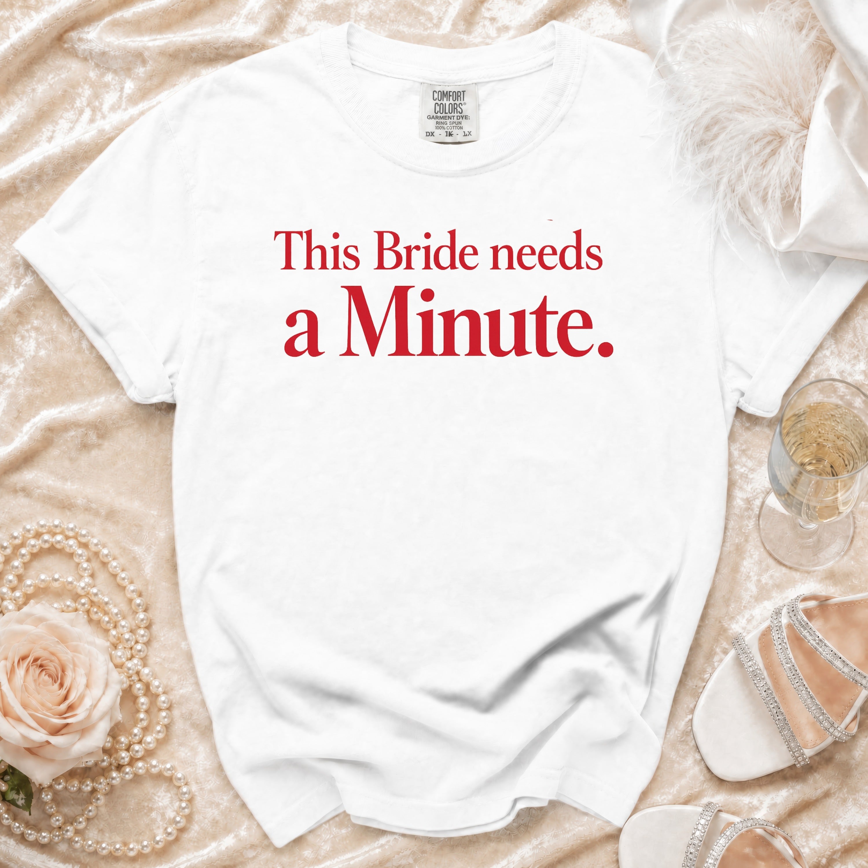 White t-shirt with red text "This Bride needs a Minute."