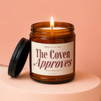Ember glass candle with lid. Label reads "Smells Like The Coven Approves Unanimously Vowed".