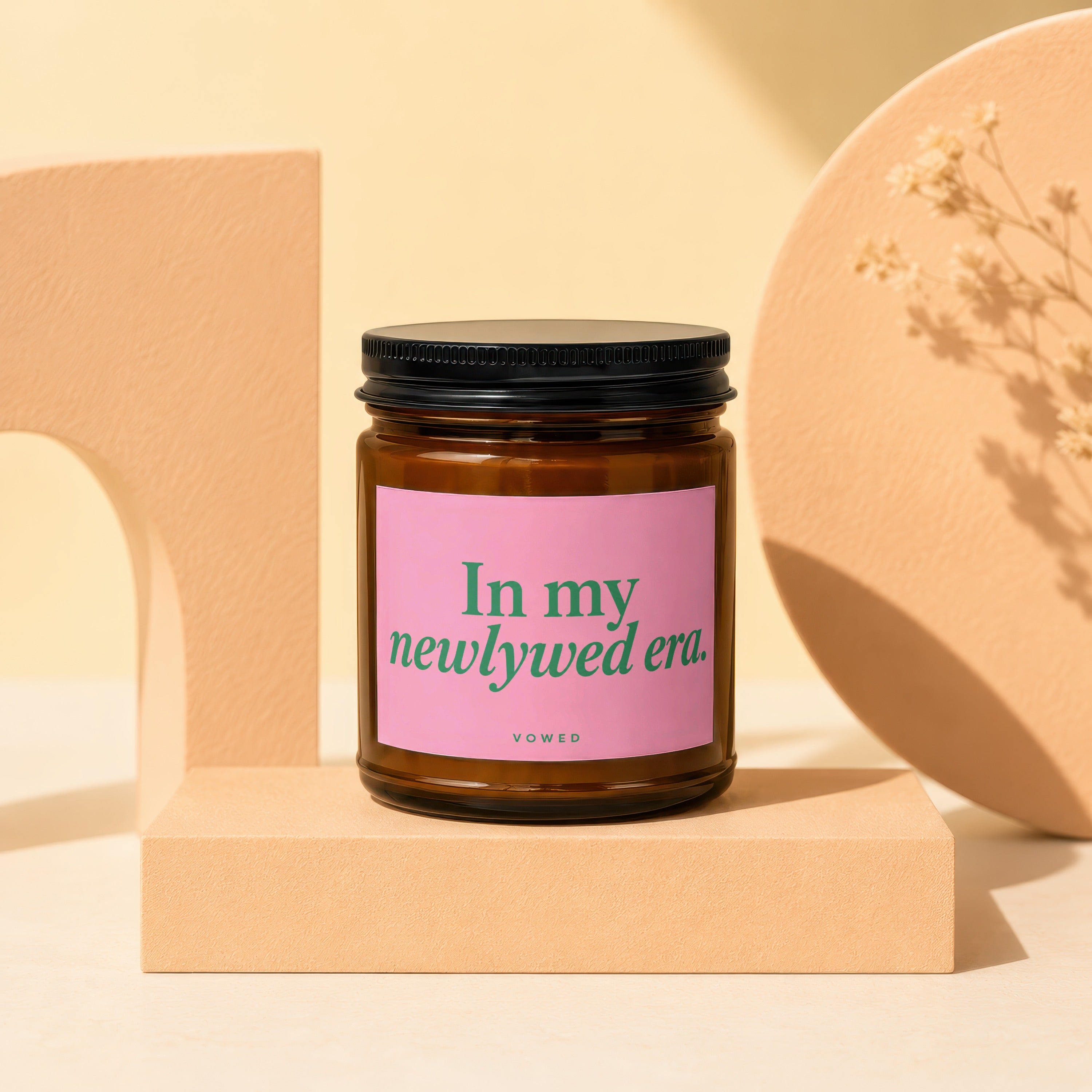 Candle with pink label reading "In my newlywed era. VOWED".