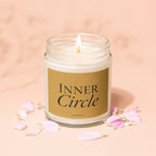 Lit candle in glass jar with "Inner Circle" label and pink petals.