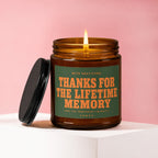 Amber glass candle burning, with label saying "Thanks for the lifetime memory".