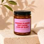 Amber candle in jar with pink label reading "Wedding planning may cause loss of sleep."