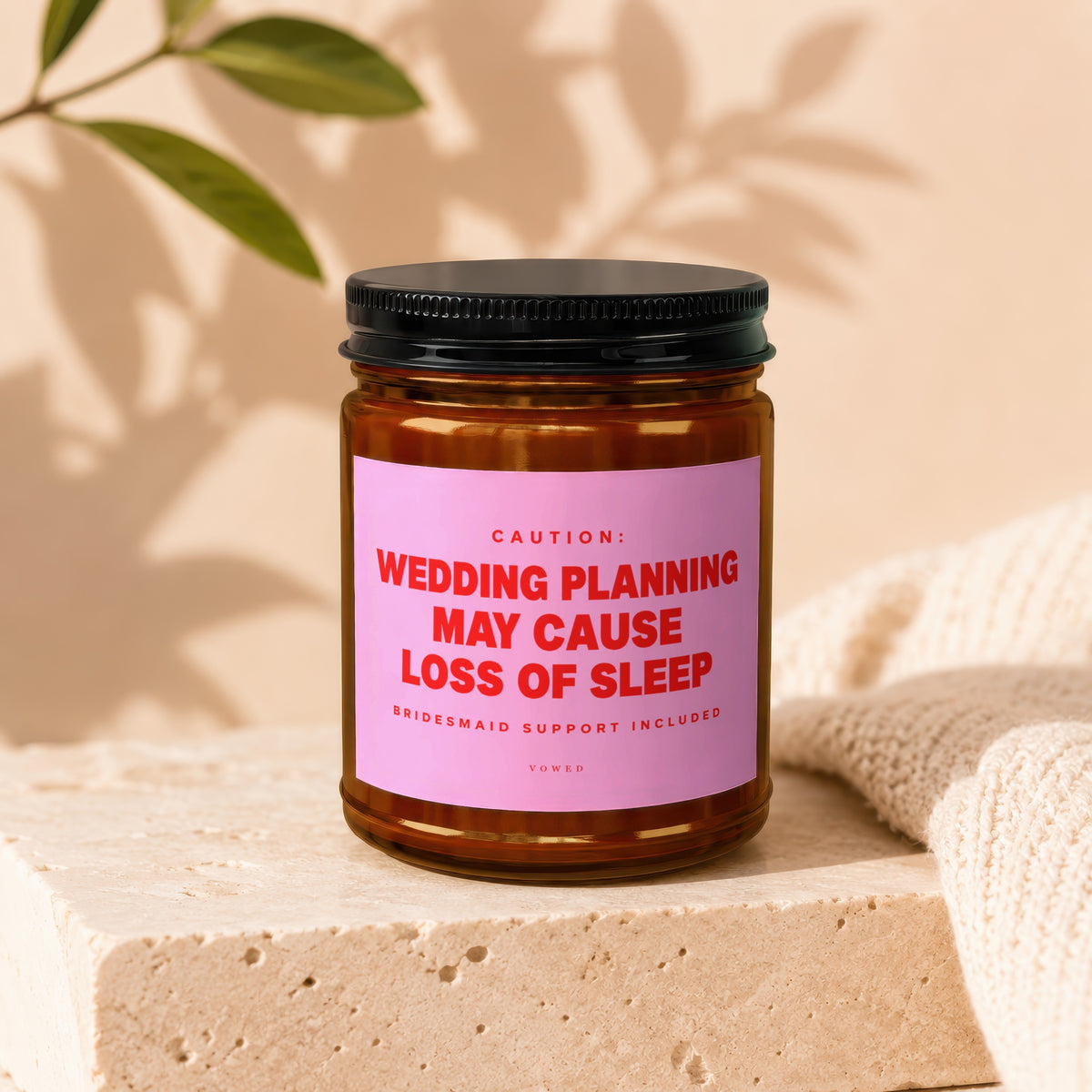 Amber candle in jar with pink label reading "Wedding planning may cause loss of sleep."