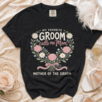 Black t-shirt with "My Favorite Groom calls me Mom, Mother of the Groom" text and floral design.