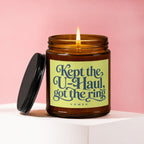 Amber jar candle with lit flame and lid off, reads "Kept the U-Haul, got the ring."