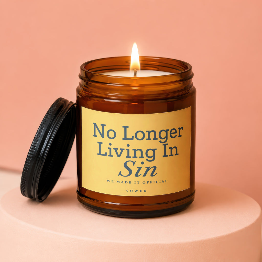 Amber jar candle with lit wick and lid off, text reads "No Longer Living In Sin".
