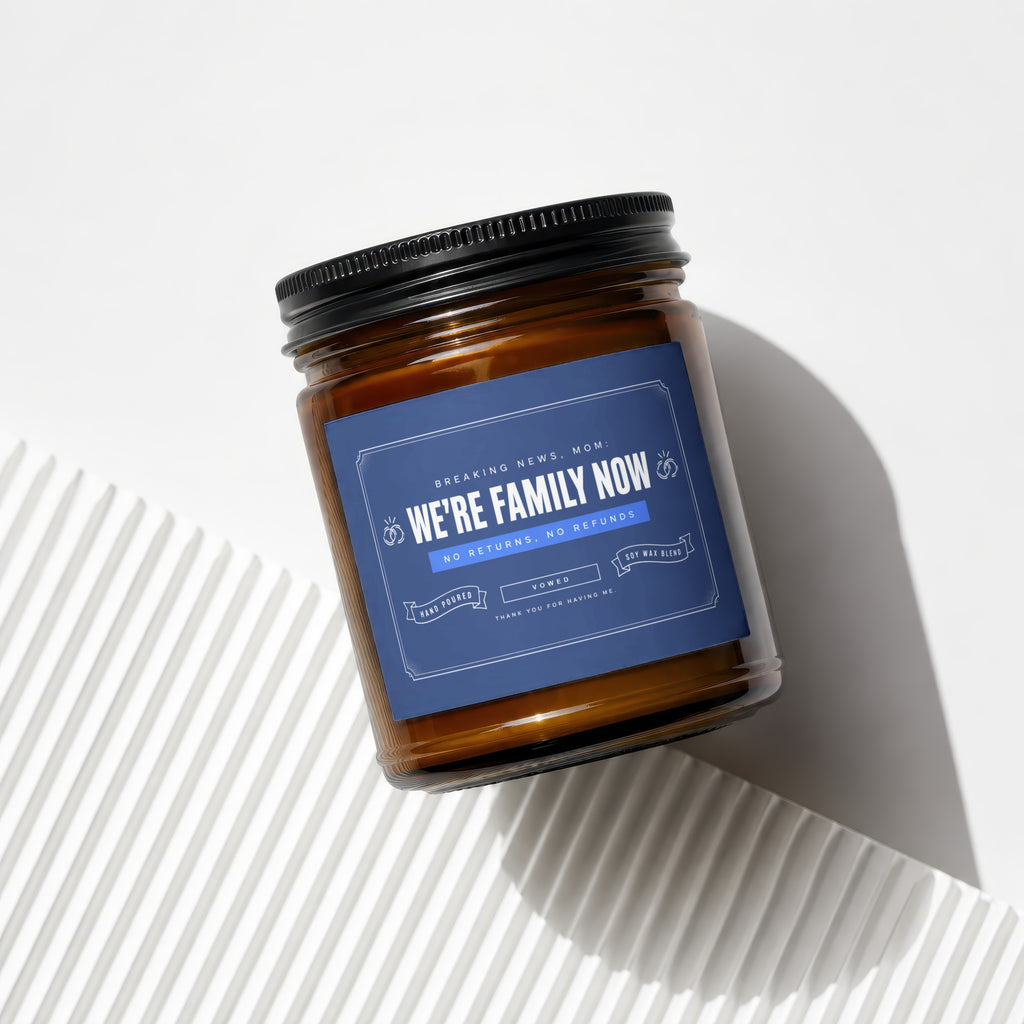 Amber jar candle with navy label that reads "We're family now."