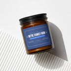 Amber jar candle with navy label that reads "We're family now."