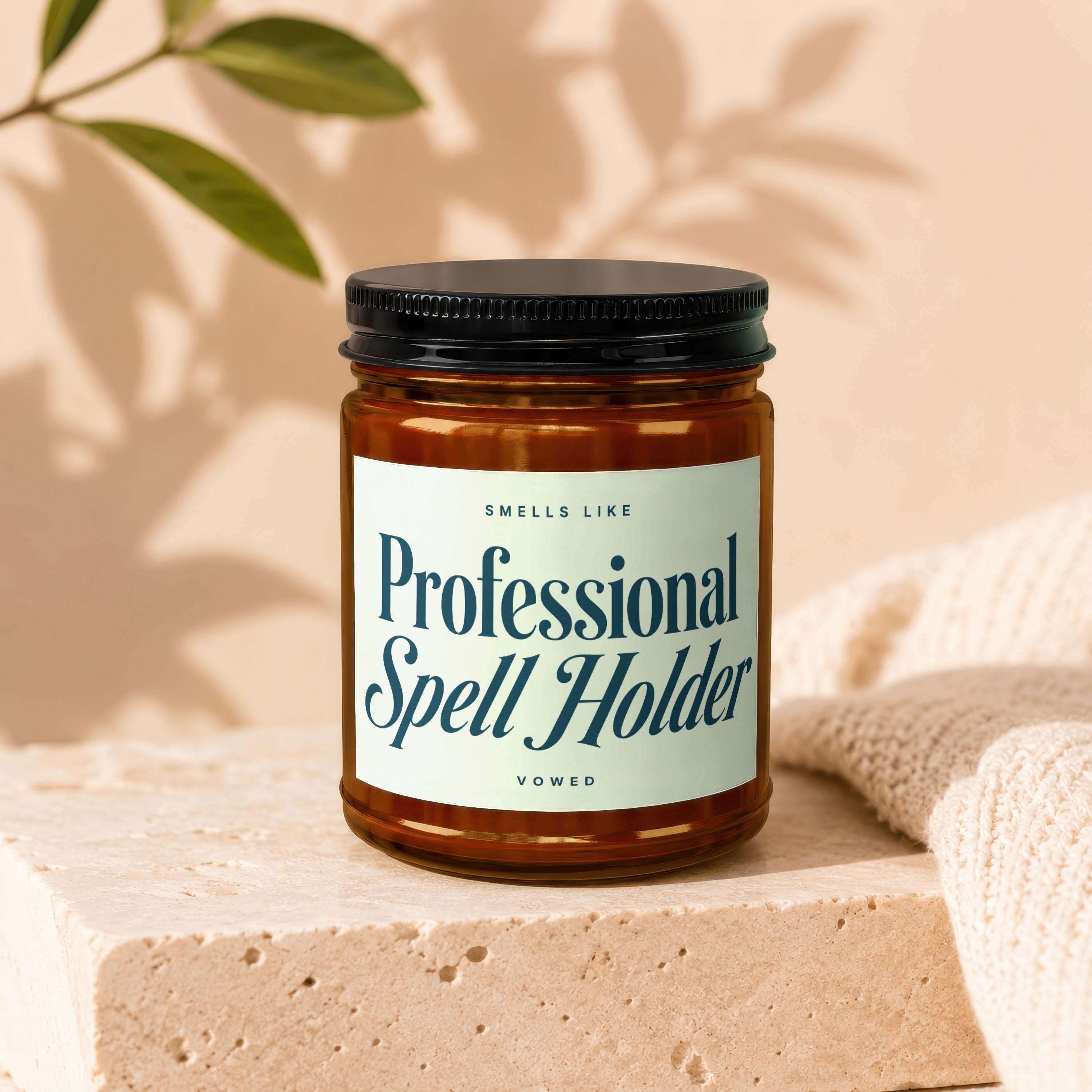 Amber jar candle labeled "Smells Like Professional Spell Holder" by Vowed.