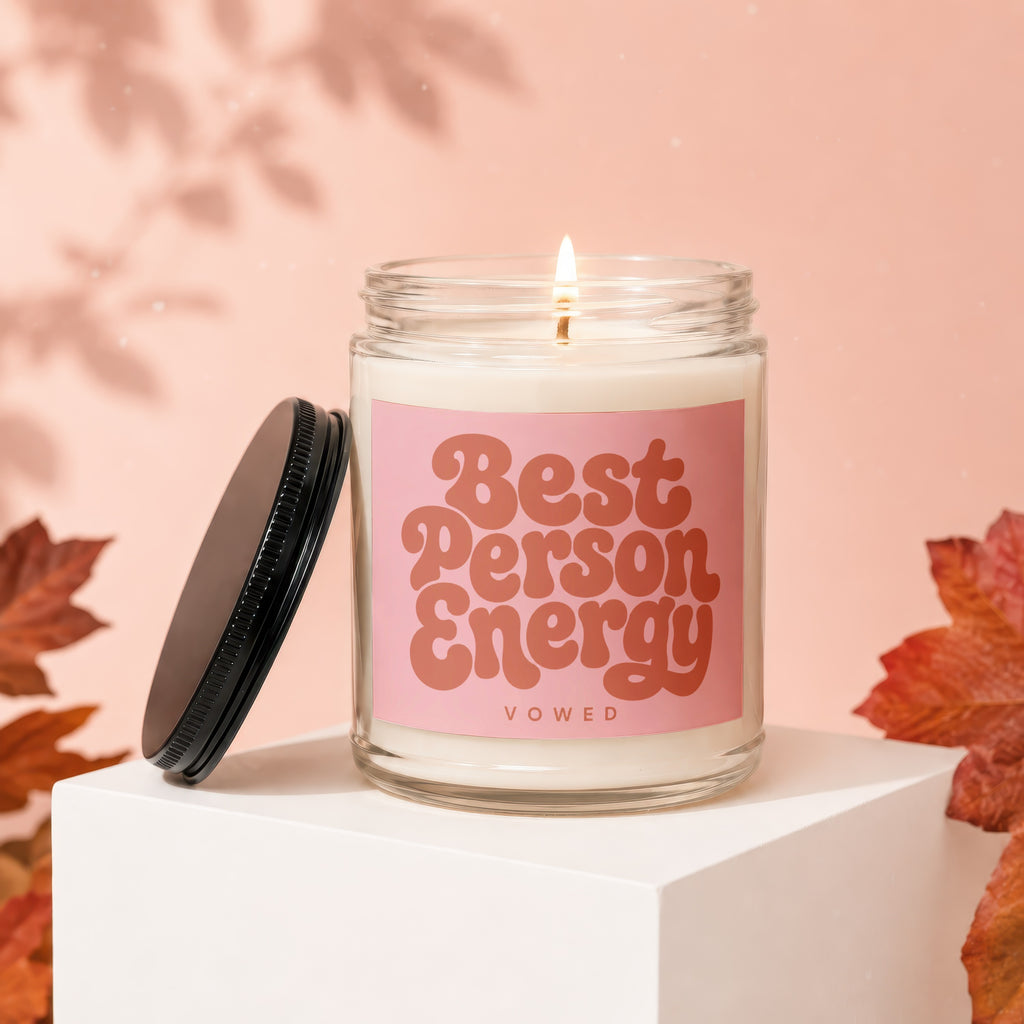 Candle with "Best Person Energy" text on pink label, with lid off.