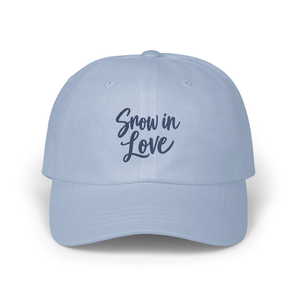 Light blue baseball cap with the embroidered dark blue text Snow in Love on the front.