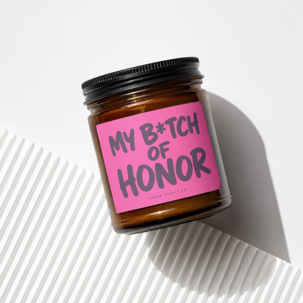 Brown glass candle with pink label reading "MY B*TCH OF HONOR VOWED CANDLE CO."