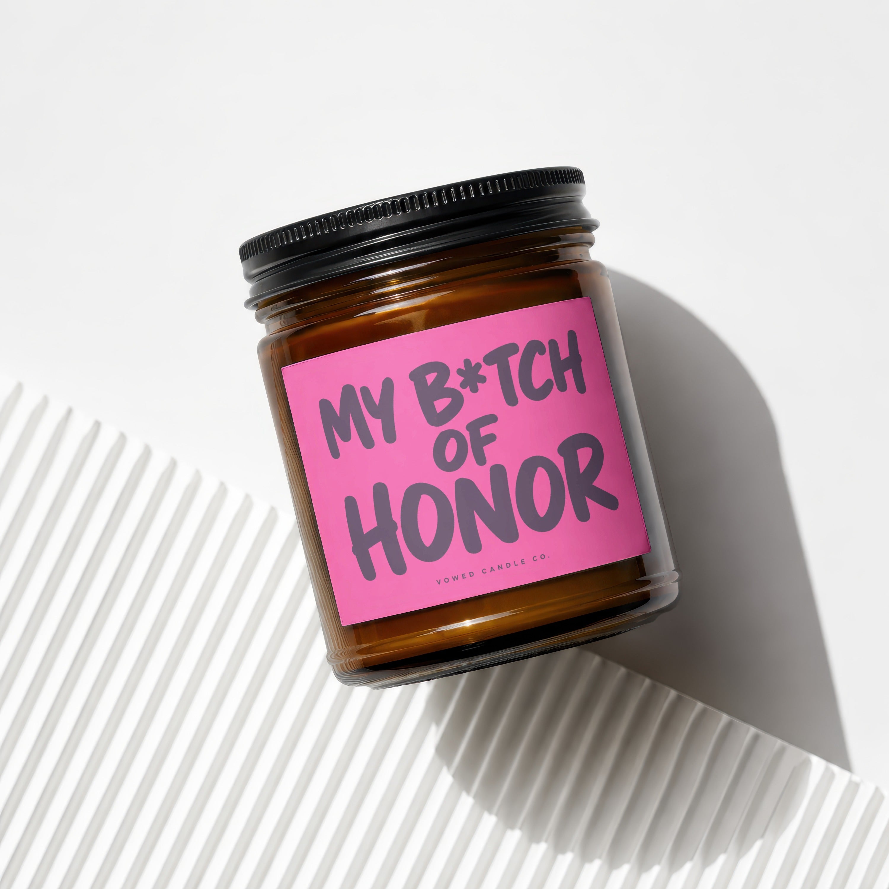 Brown glass candle with pink label reading "MY B*TCH OF HONOR VOWED CANDLE CO."