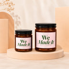 Two VOWED candles, "We Made It," sit on stands with decorative objects.