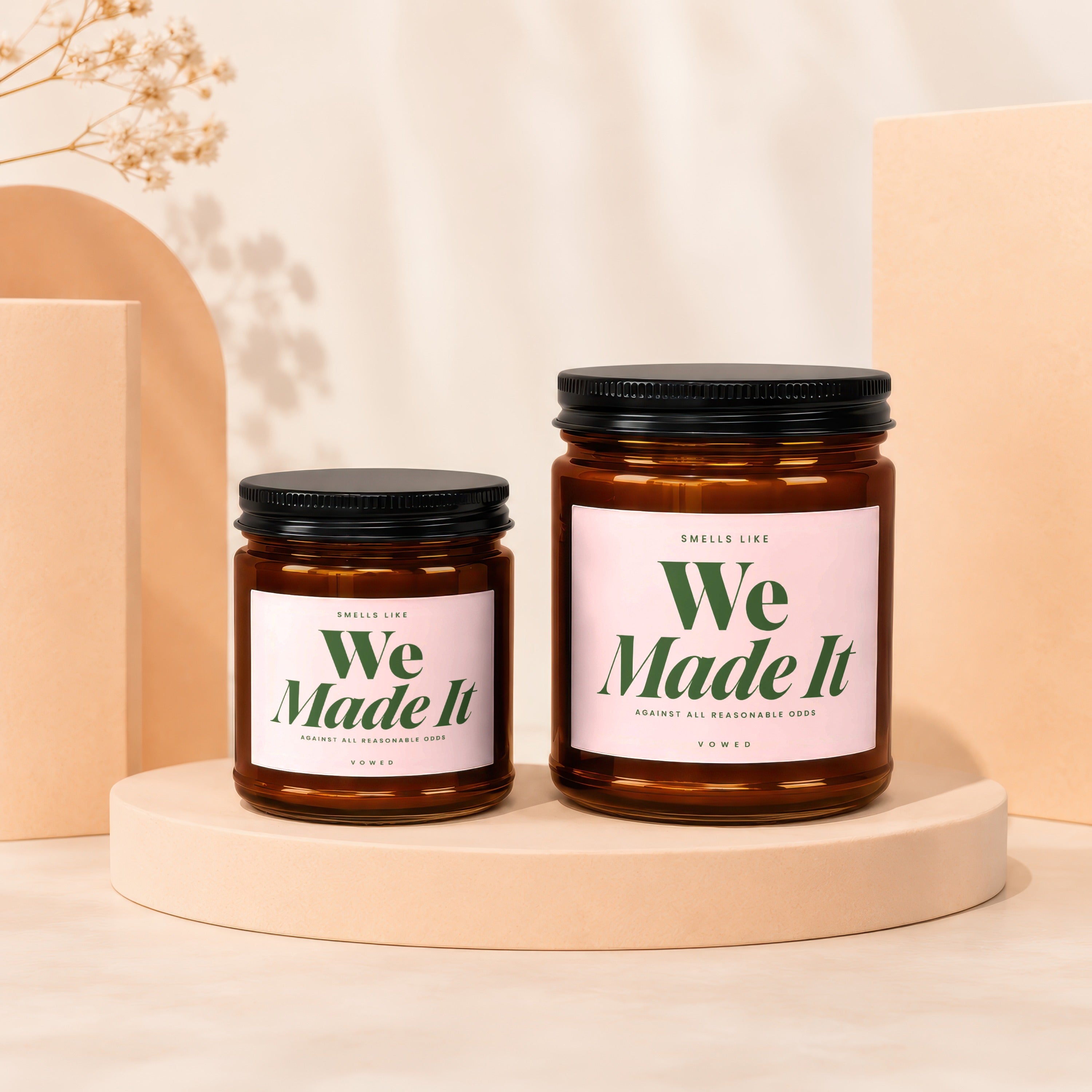Two VOWED candles, "We Made It," sit on stands with decorative objects.