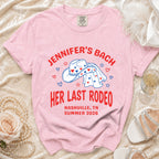 Pink t-shirt with "Jennifer's Bach Her Last Rodeo" text and cowboy hat graphic.