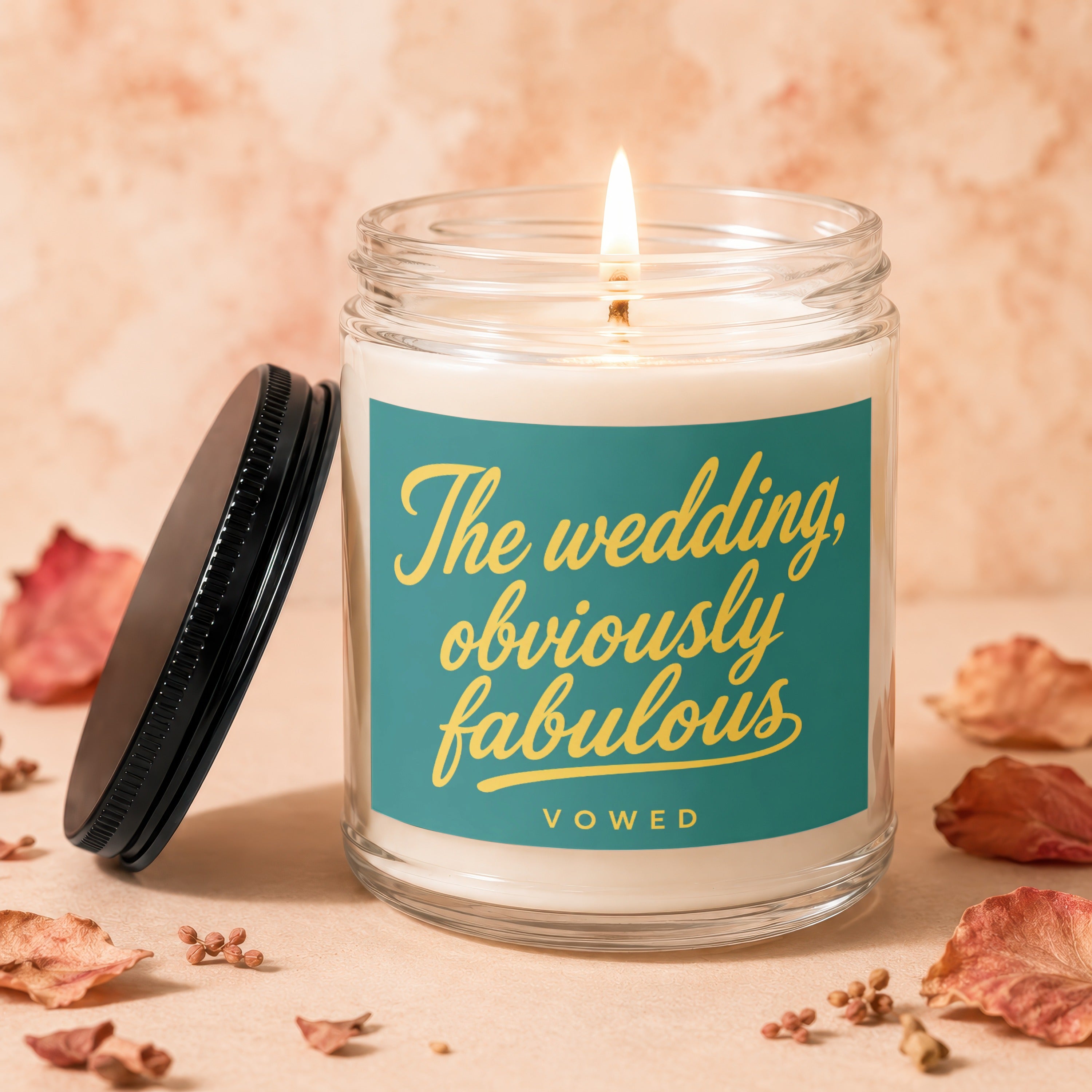 Candle with teal label reading "The wedding, obviously fabulous - VOWED."