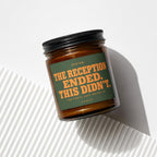 Amber jar candle with green label reading "THE RECEPTION ENDED. THIS DIDN'T."