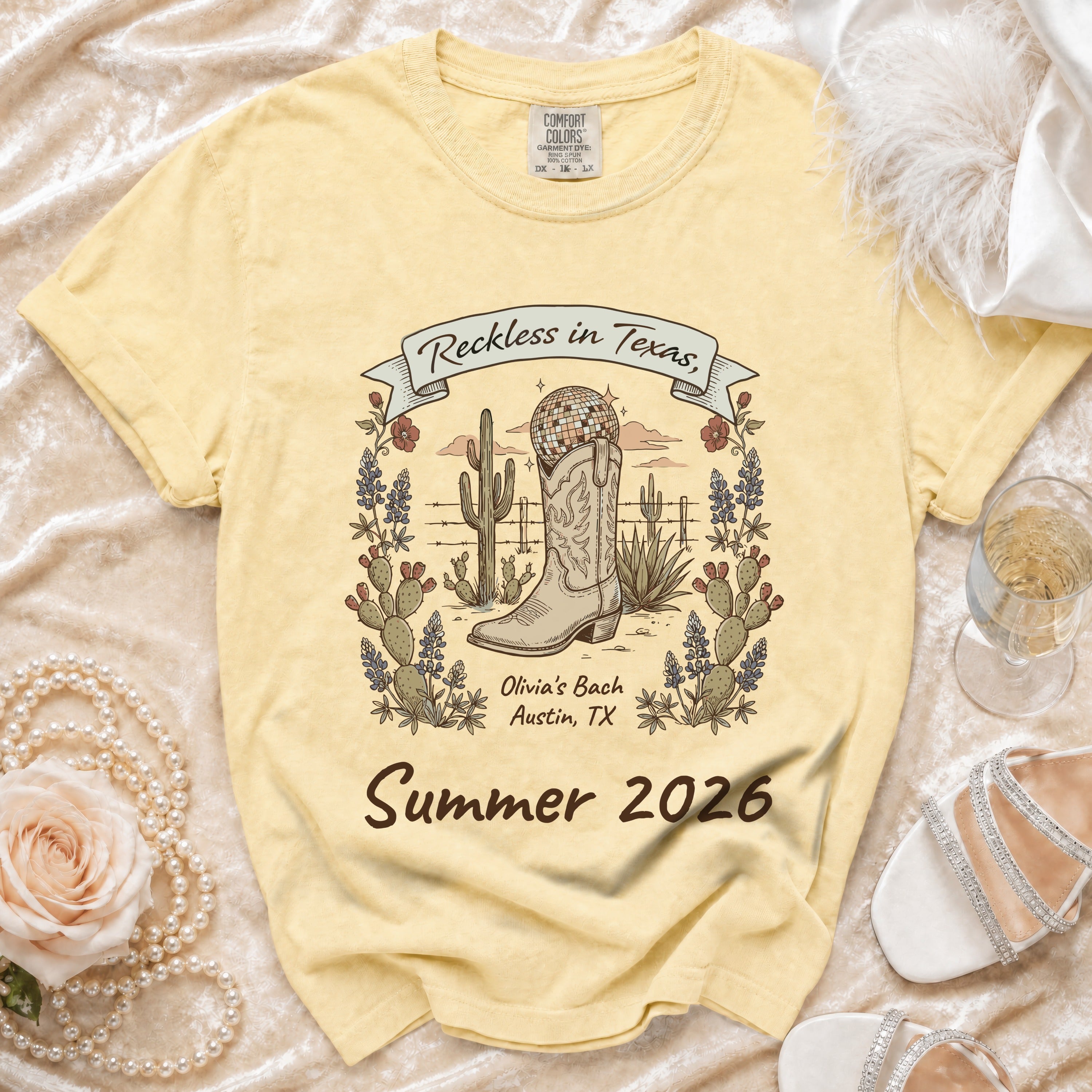 Light yellow t-shirt with "Reckless in Texas" graphic for "Olivia's Bach Summer 2026".