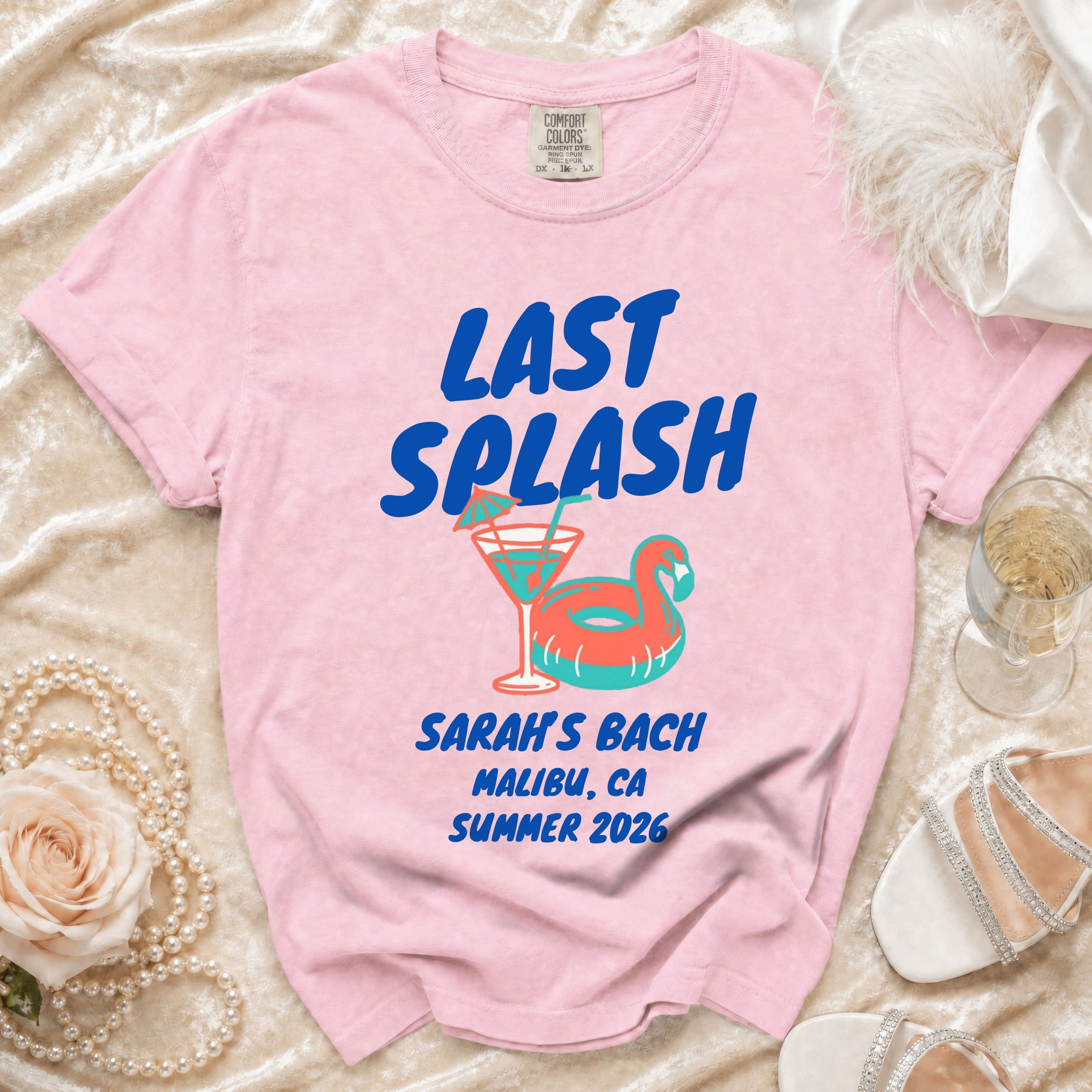 Pink t-shirt with "LAST SPLASH" text, cocktail, and ring float.