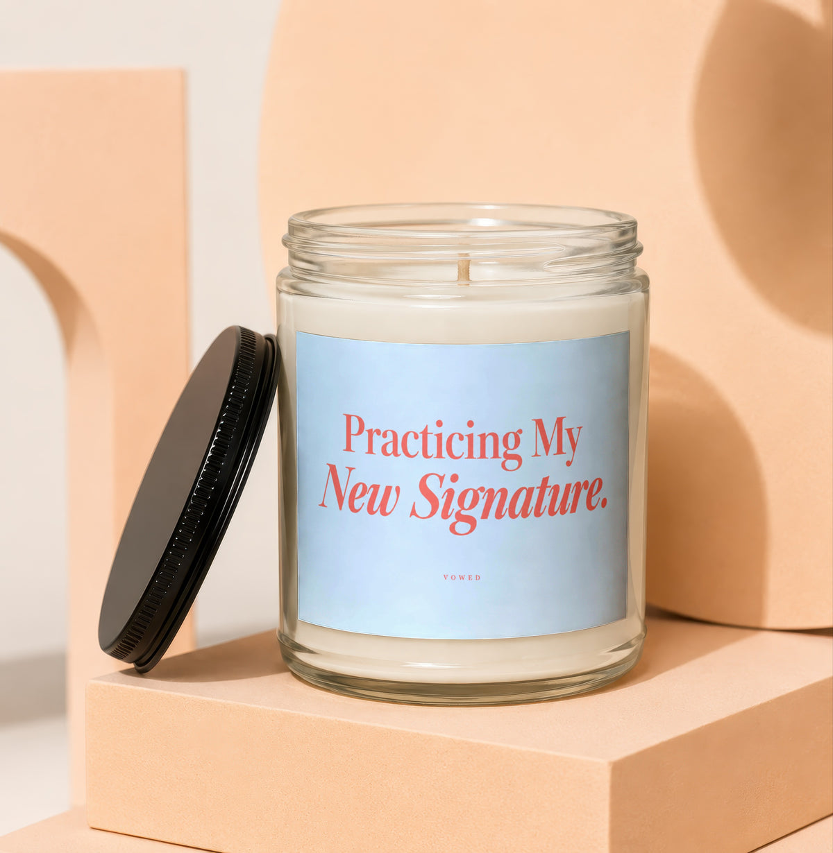 Glass candle with label reading "Practicing My New Signature. VOWED".