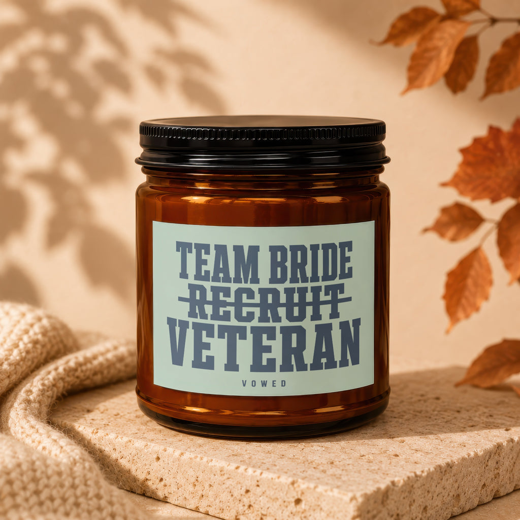 Amber candle in glass jar with "Team Bride Recruit Veteran Vowed" label.